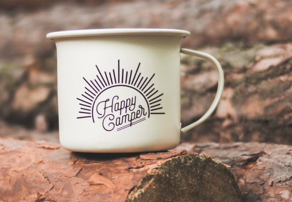 white happy camper printed cup on brown wooden