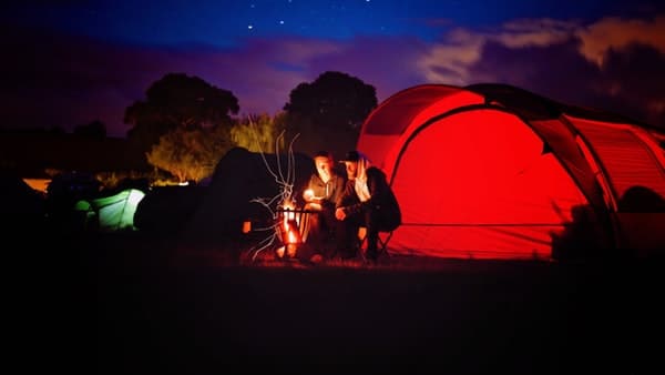 couple sitting beside tent