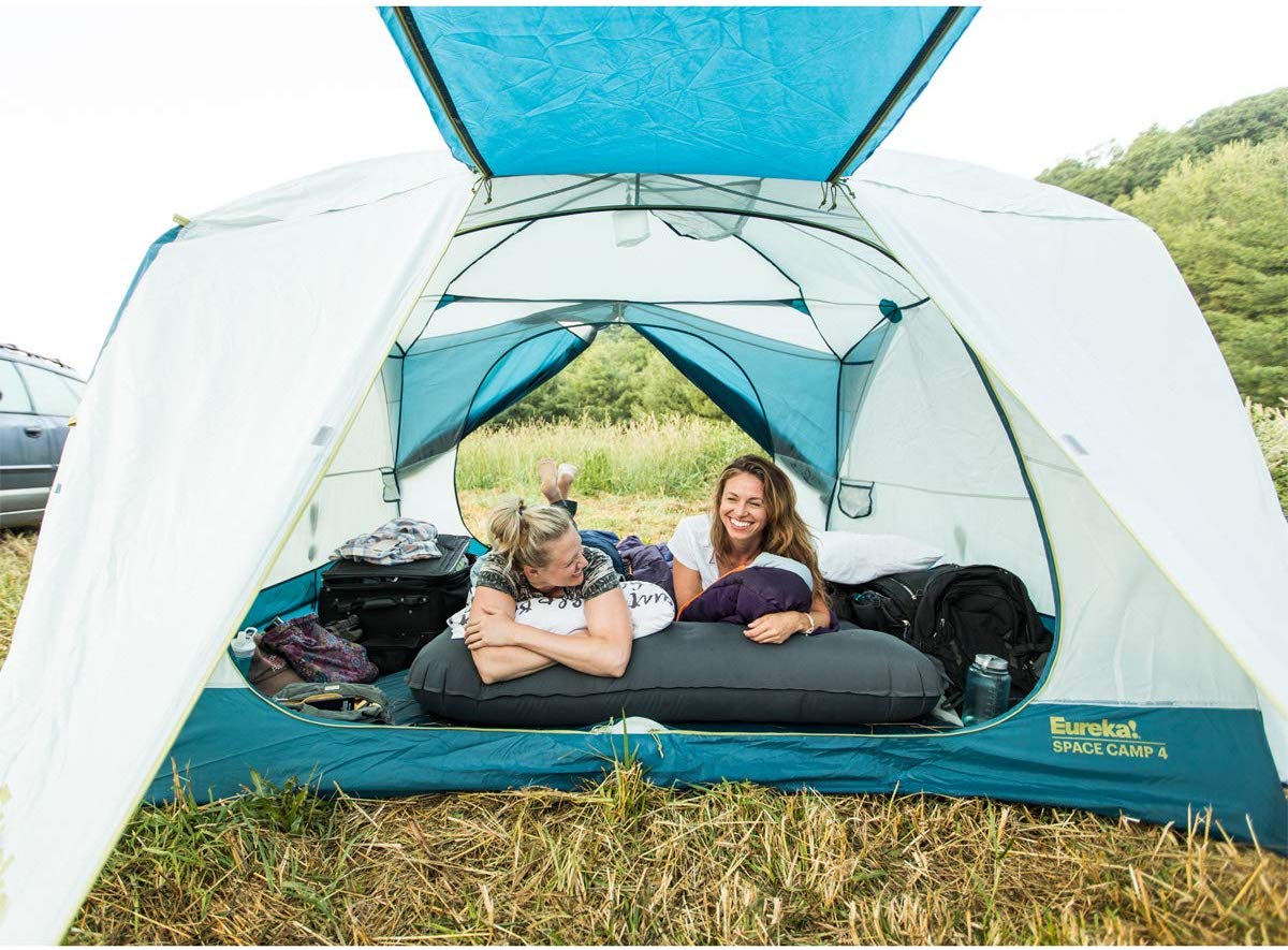 two woman inside a white and blue eureka tent