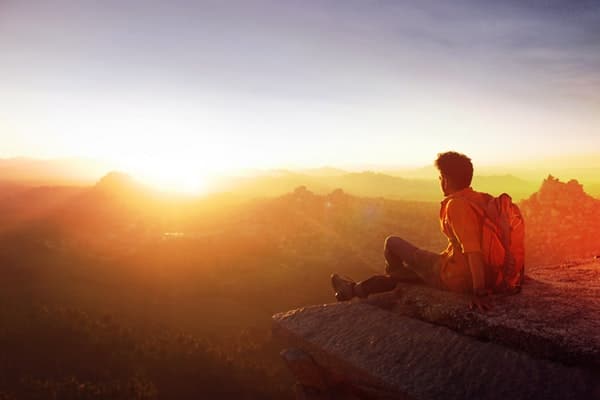 Man sitting on edge watching sunset