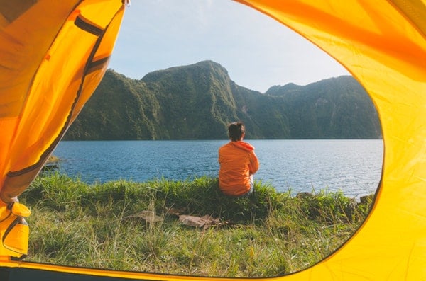 person sitting facing body of water