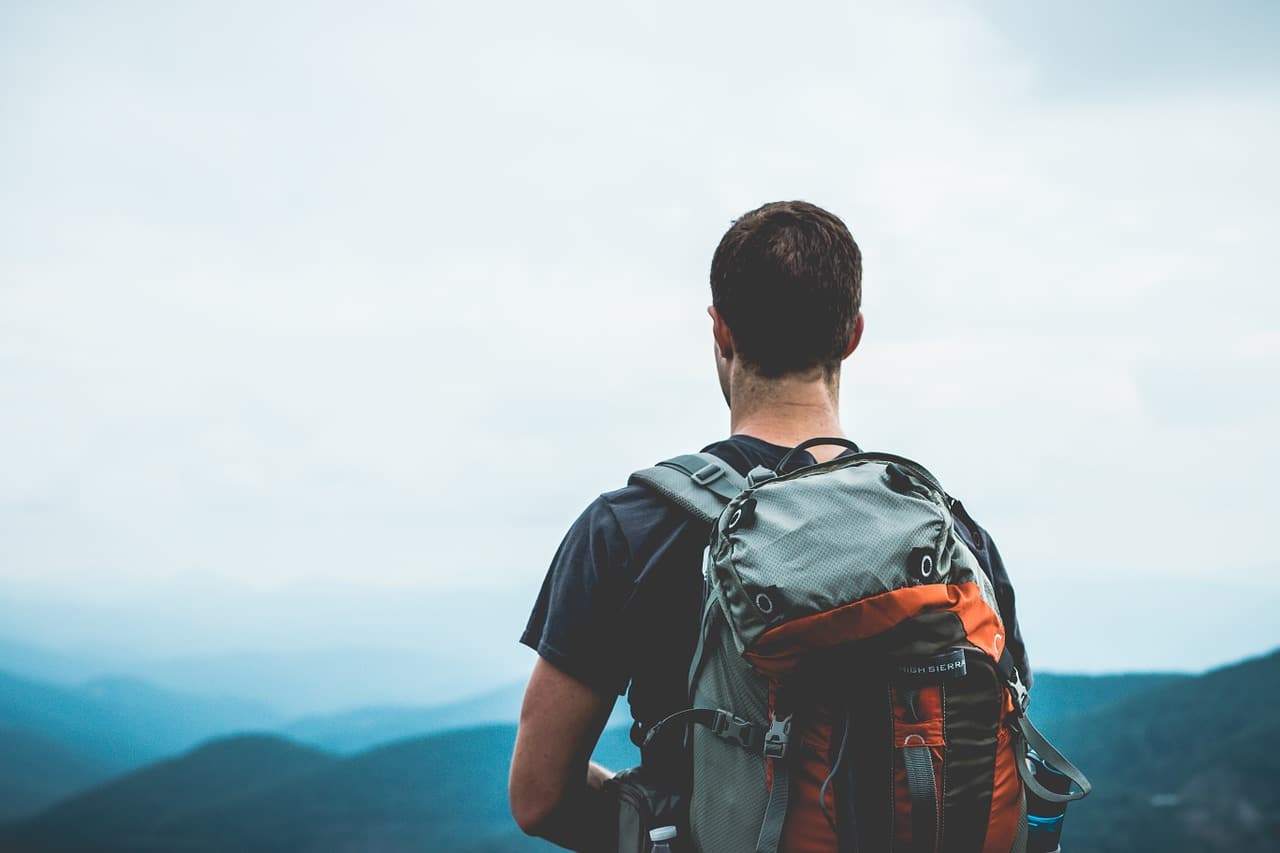 Man with a gray and orange hiking backpack