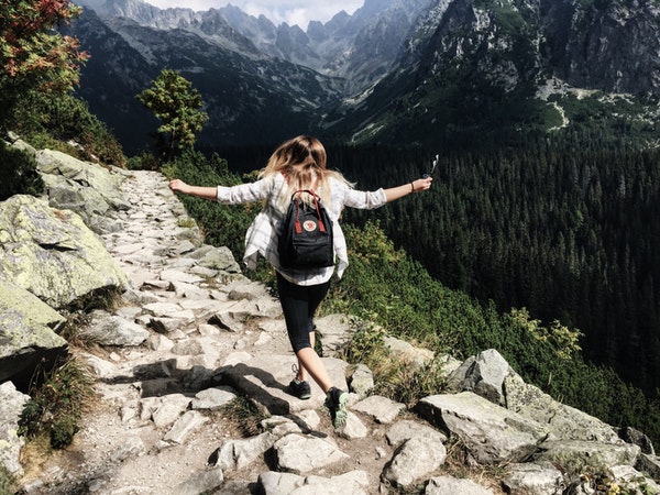 woman hiking on a mountain near cliff