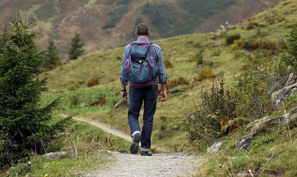 man hiking down a trail