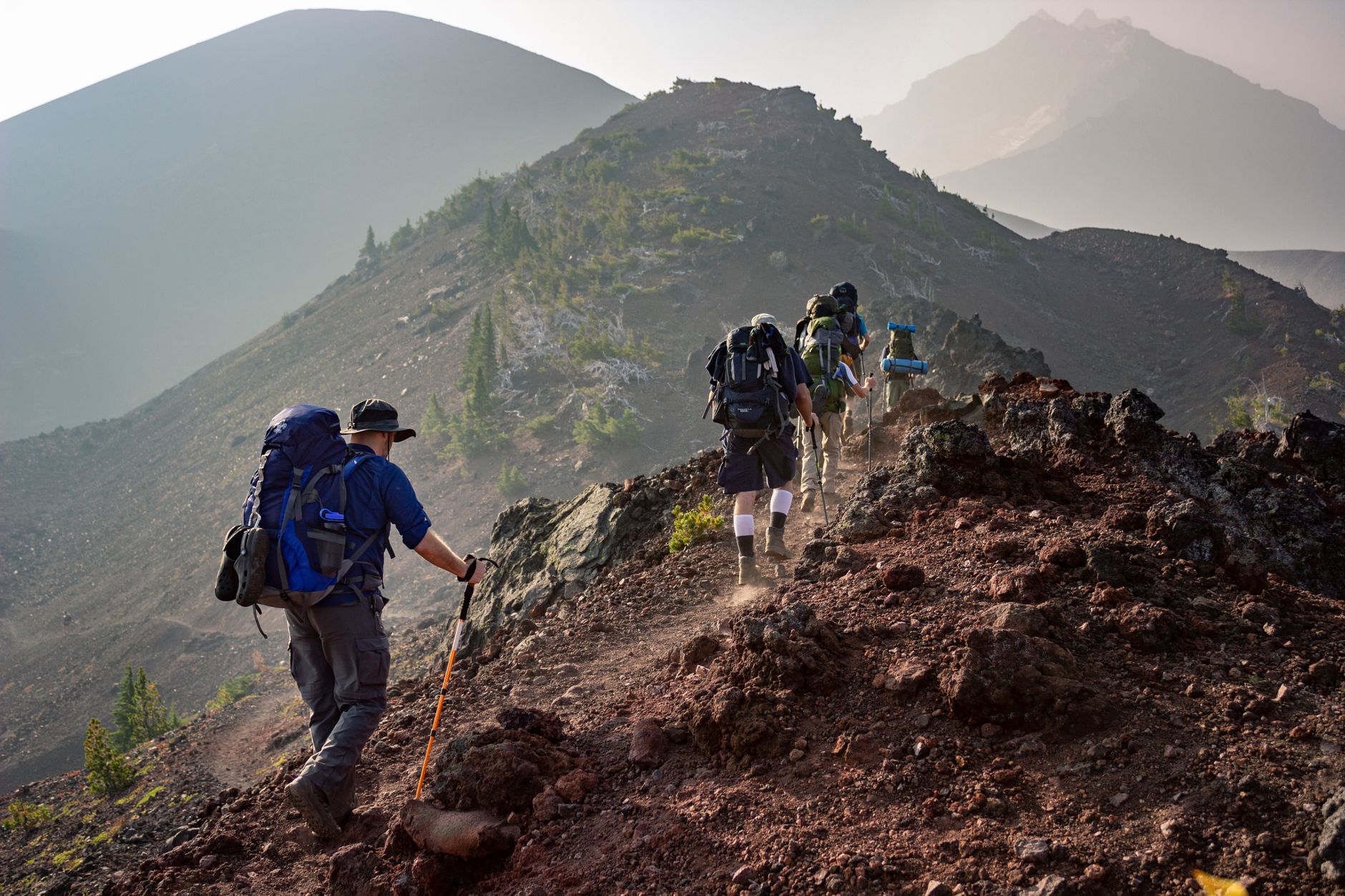 People are holding a the best trekking poles while walking on the trail head