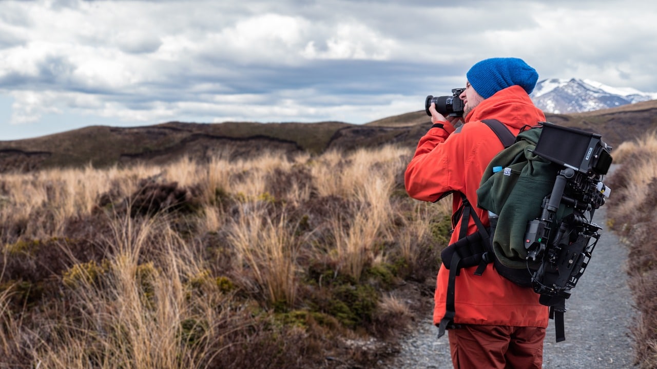 Man in orange jacket taking a photo