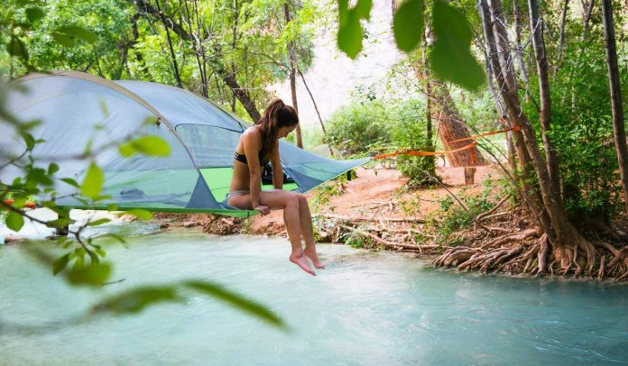 Woman Sitting on the Tentsile Tent Stingray Model Tree House Tent Over the River