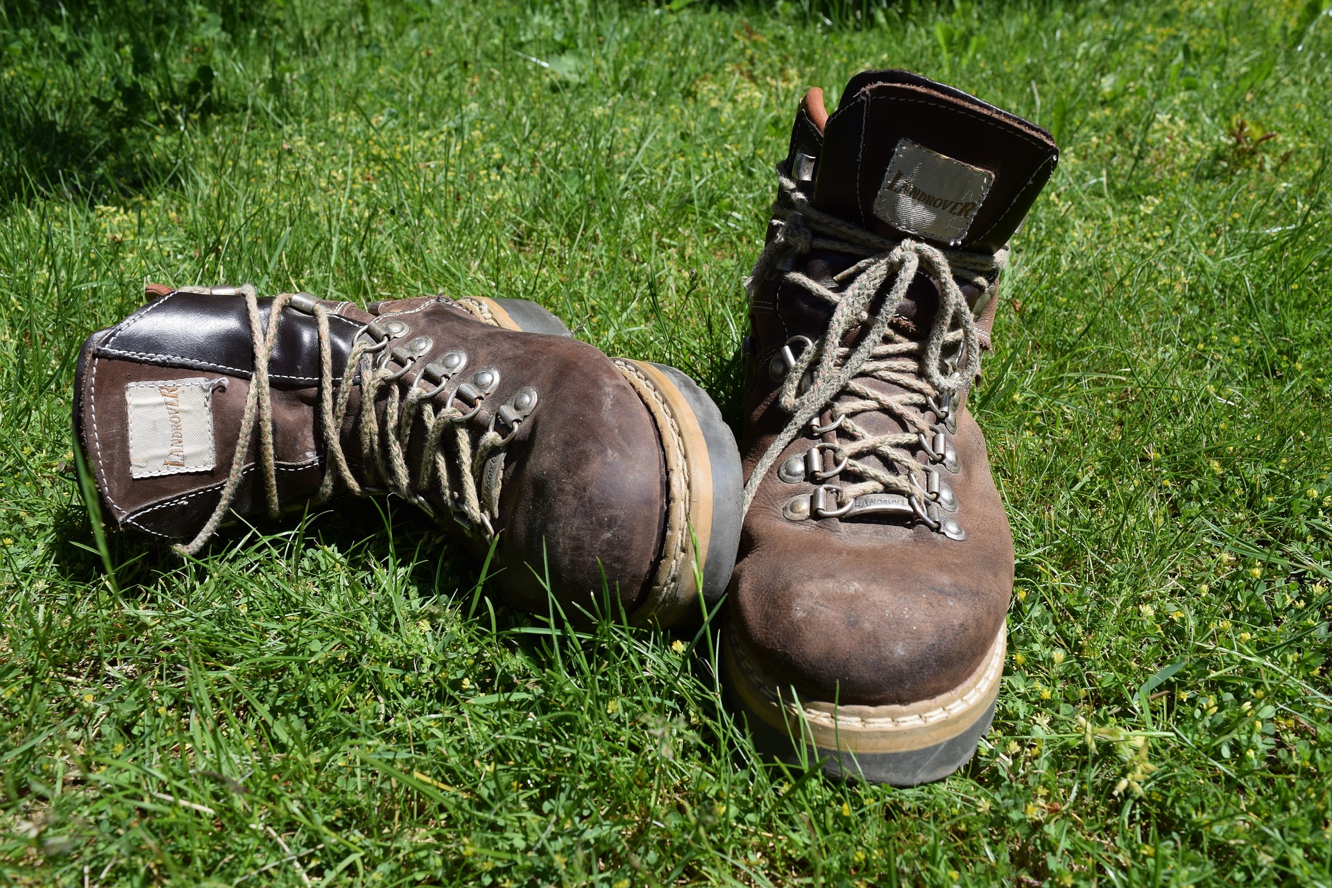 Ahnu hiking boots placed on the green grass